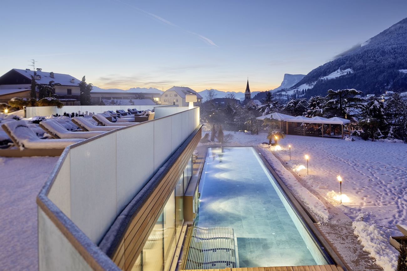 Aerial view over a hotel with an infinity pool in the snow