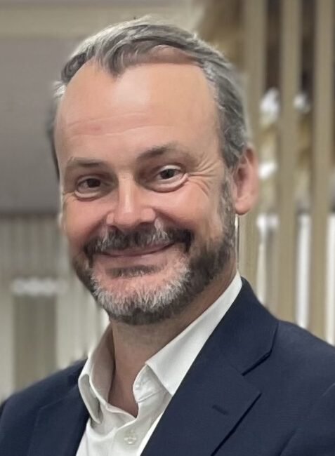Man in blue suit smiling at camera