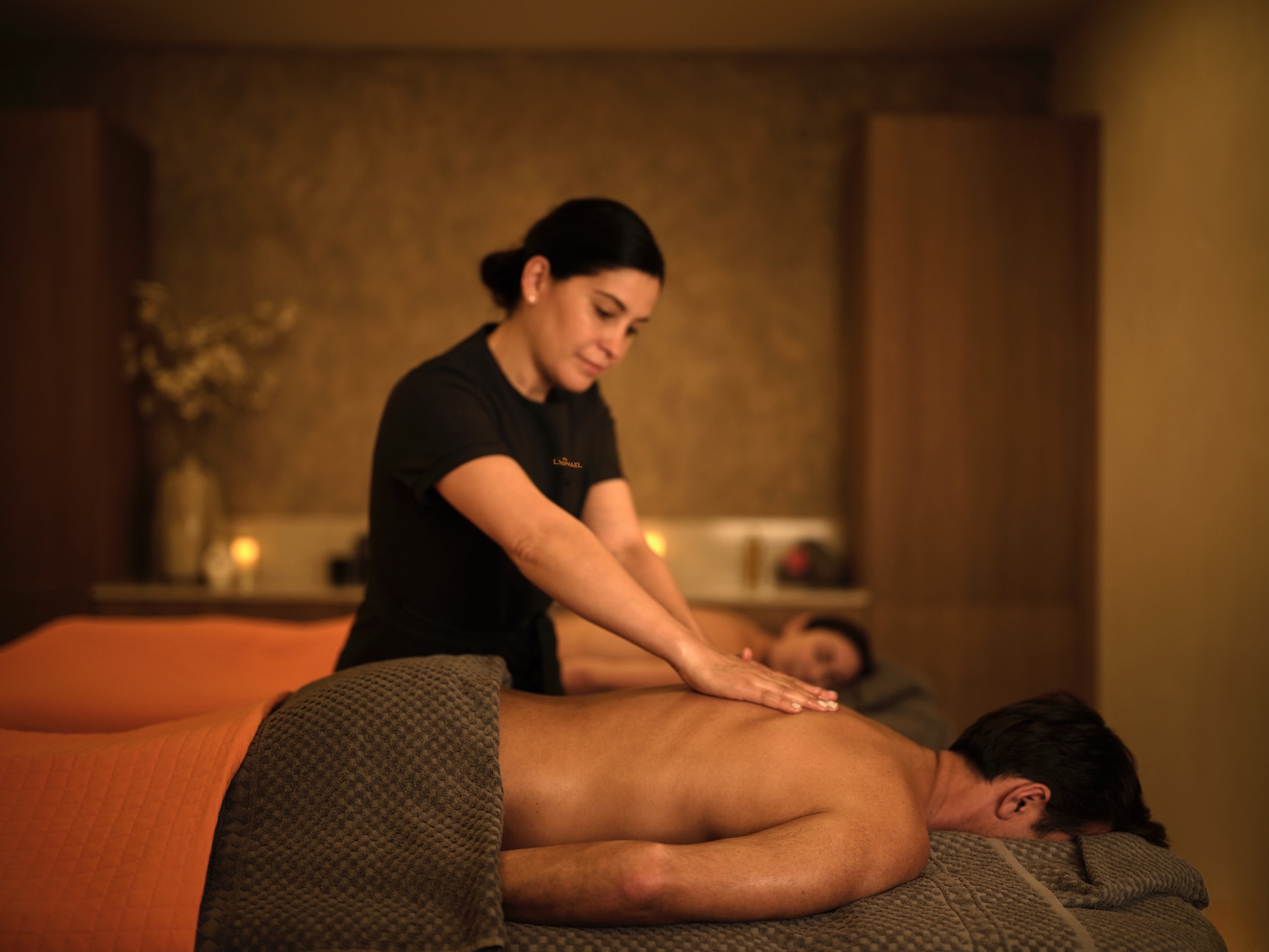 woman giving man a back massage in a spa