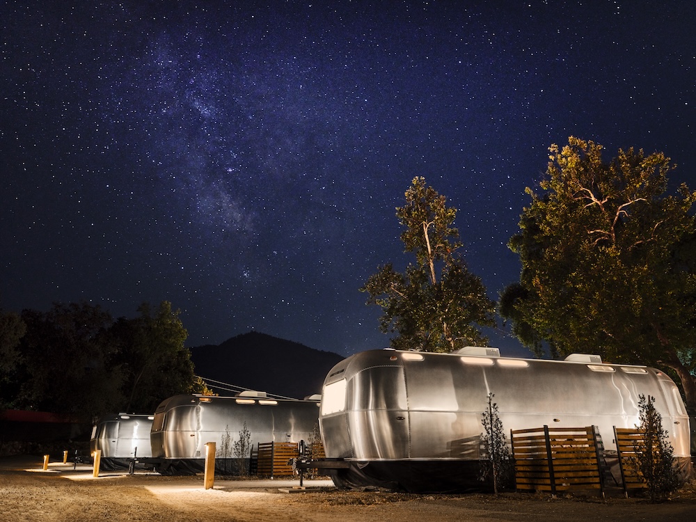 a row of static caravans with a starry night sky backdrop