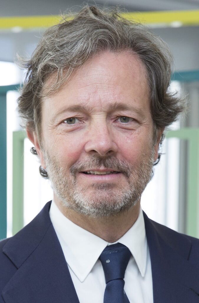 Headshot of older man wearing a suit and tie