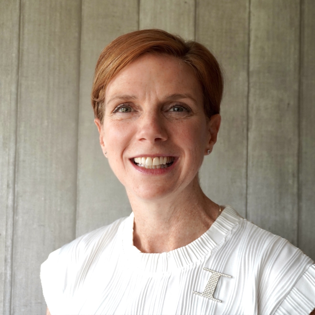Headshot of red head with short pixie cropped hair