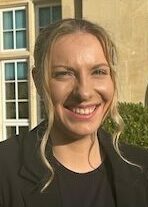 Woman wearing all black posing outside a grand facade