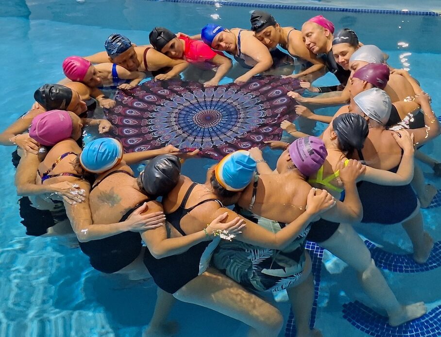 Group of swimmers hugging in a circle