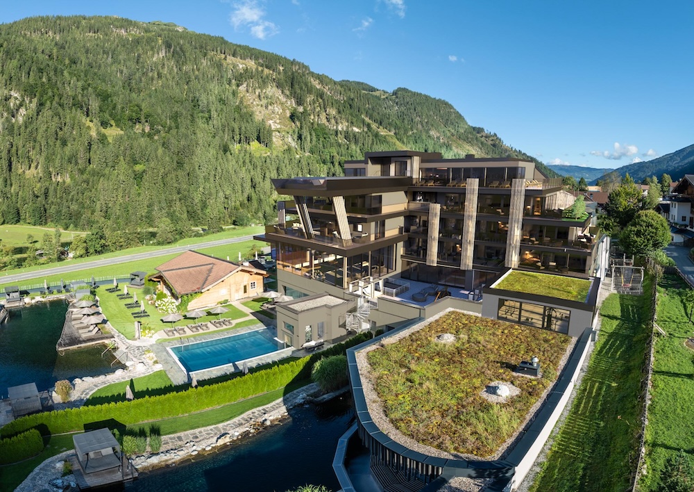 External aerial view of an alpine hotel with a mountain backdrop
