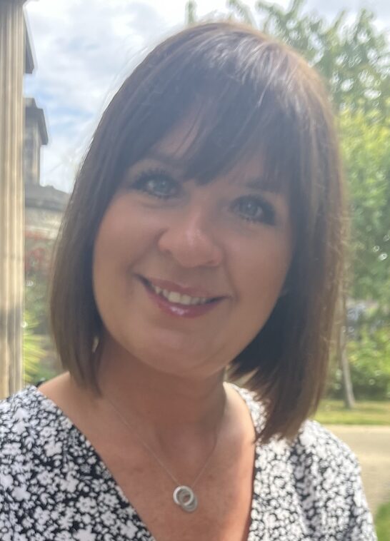 Woman in floral dress smiling for camera