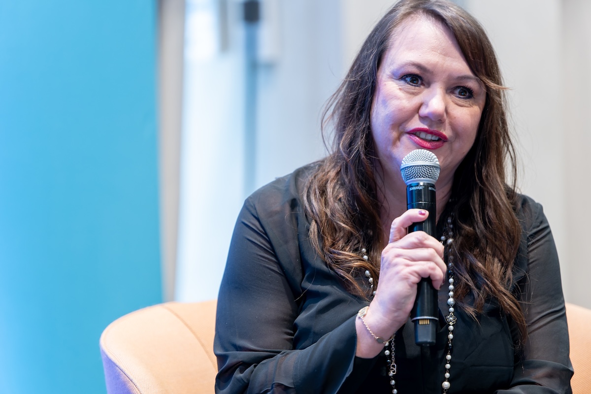 Dark haired woman talking into microphone