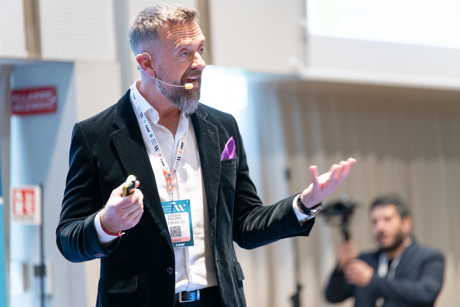 Man on stage speaking and gesturing with hands