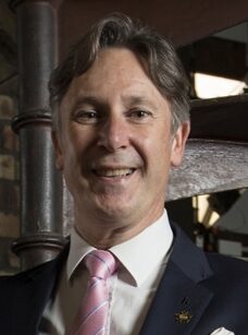 man in a suit standing on a staircase at The Balmoral