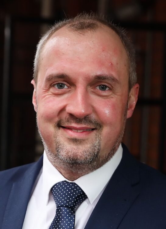 Headshot of man in blue suit and tie