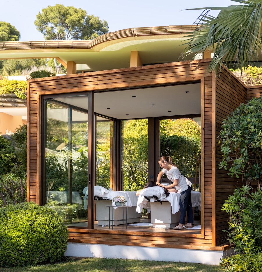 A therapist giving a massage in an outdoor treatment room