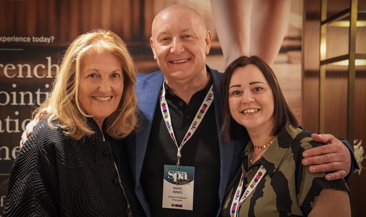 Three people posing for the camera at a business event