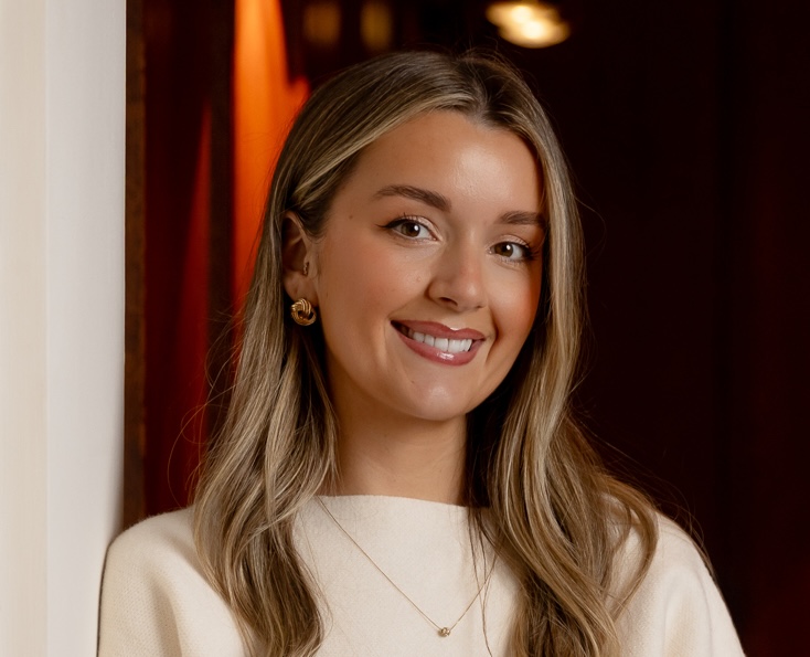 Smiling woman in cream top with long hair