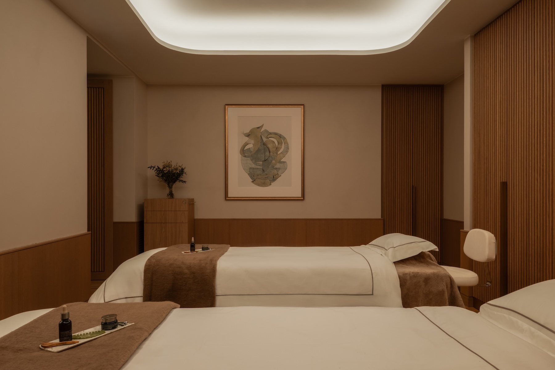A spa treatment room with two therapy beds