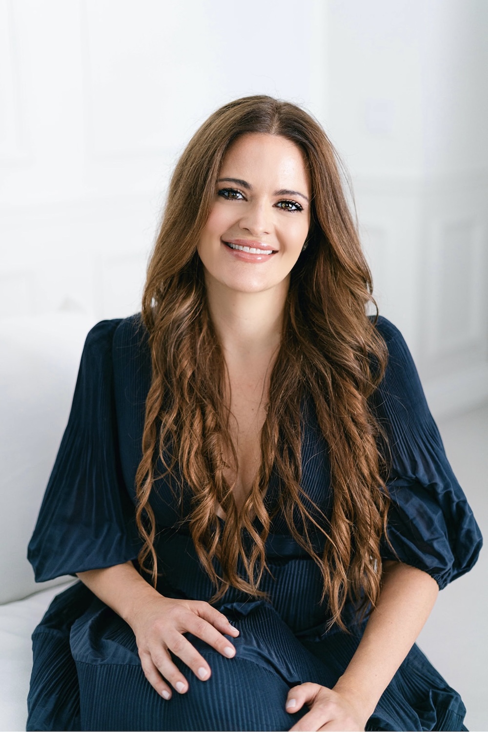 Portrait image of woman with long dark hair and blue dress