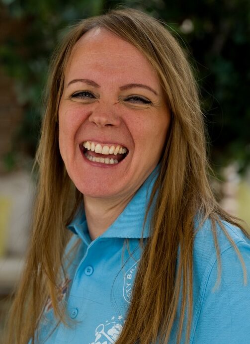 Smiling woman with hand on hip in blue tshirt