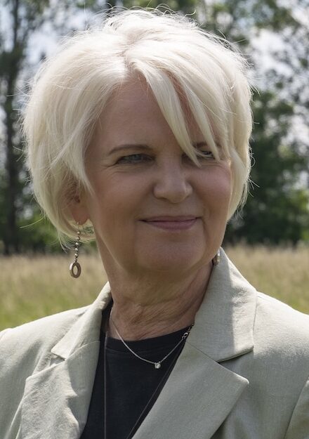 Woman stodd outside set against wild flowers
