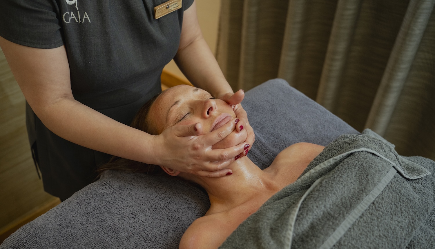 Therapist's hands on a woman's face in a spa