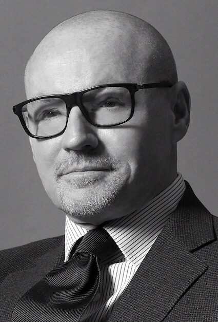 Bald man in a suit and tie posing for the shot