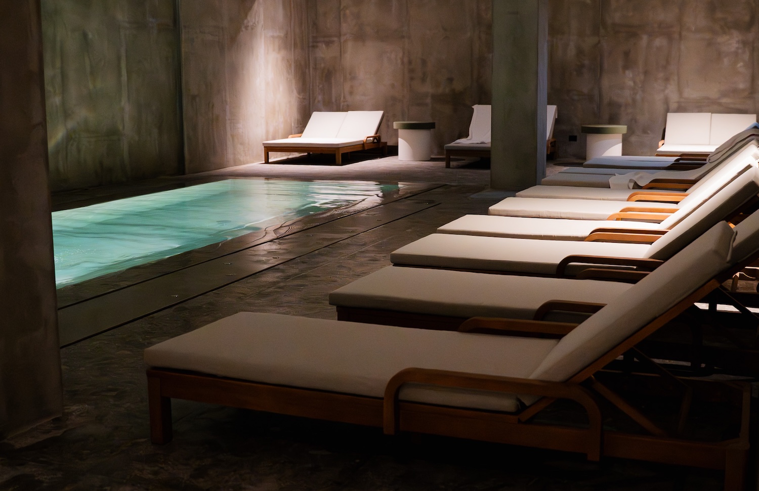 Indoor pool in subterranean spa with loungers along the side