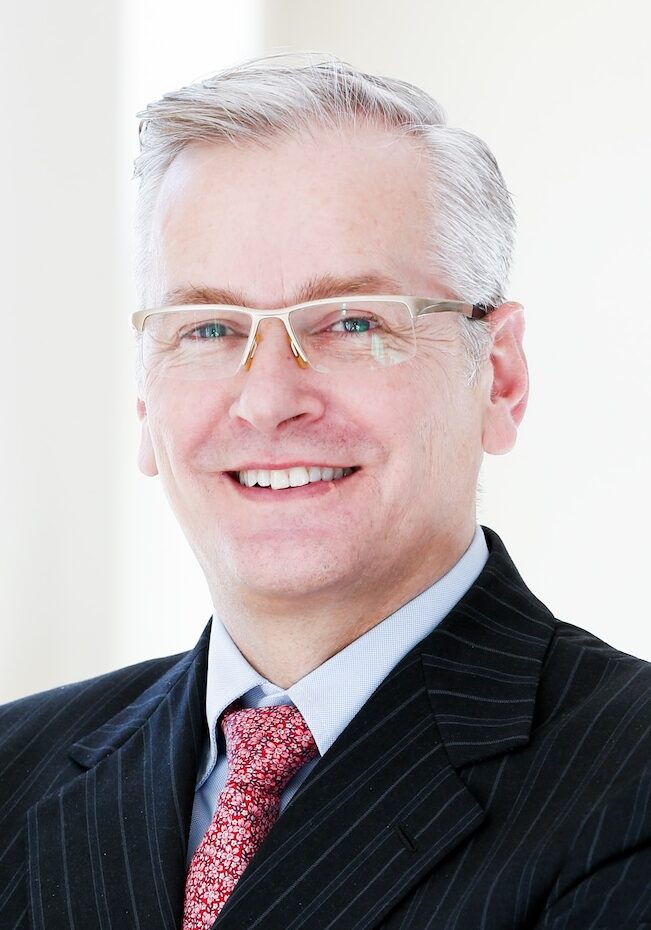 Grey haired man in dark suit