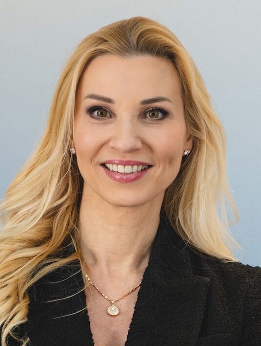Blonde woman smiling with arms folded