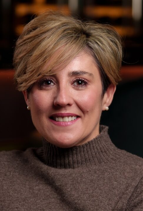 Headshot of blonde woman in jumper dress