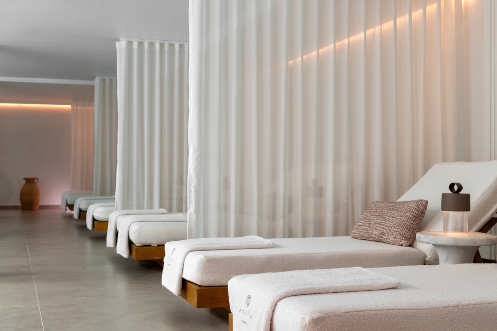 A row of spa loungers separated by gauzy curtains
