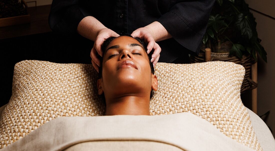 Spa therapist giving woman a facial