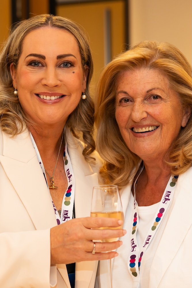 Two women in white smiling