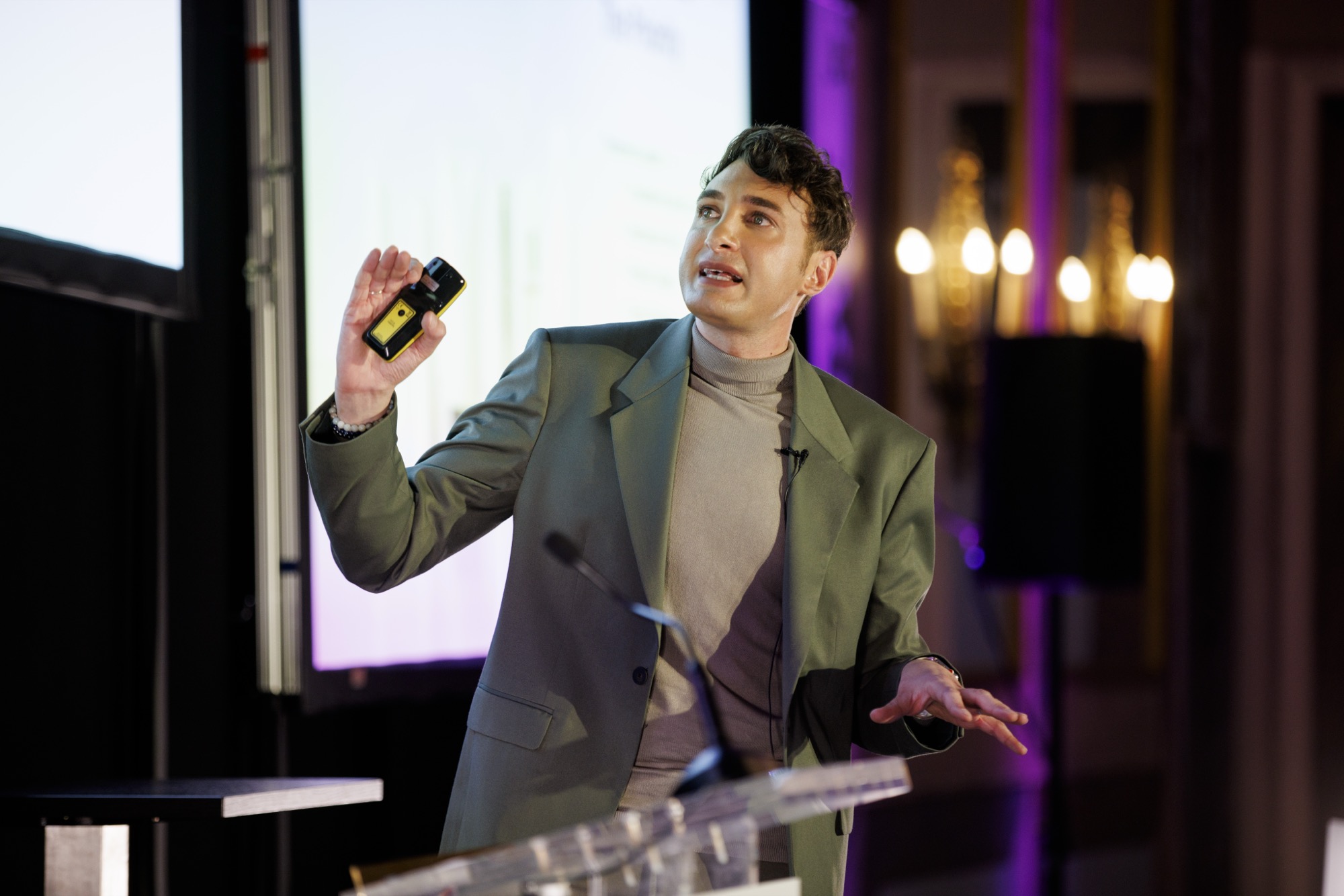 Man on stage gesticulating as he speaks