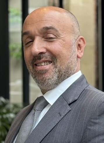 Man in grey suit posing for picture
