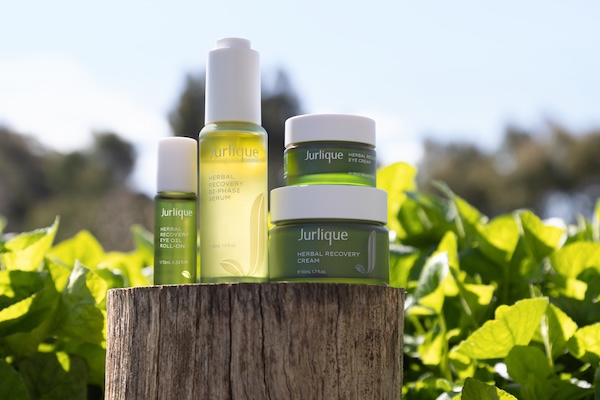 Jurlique product range sitting on a sun off tree trunk in the sun