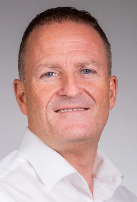 man in short sleeve white shirt smiling at camera