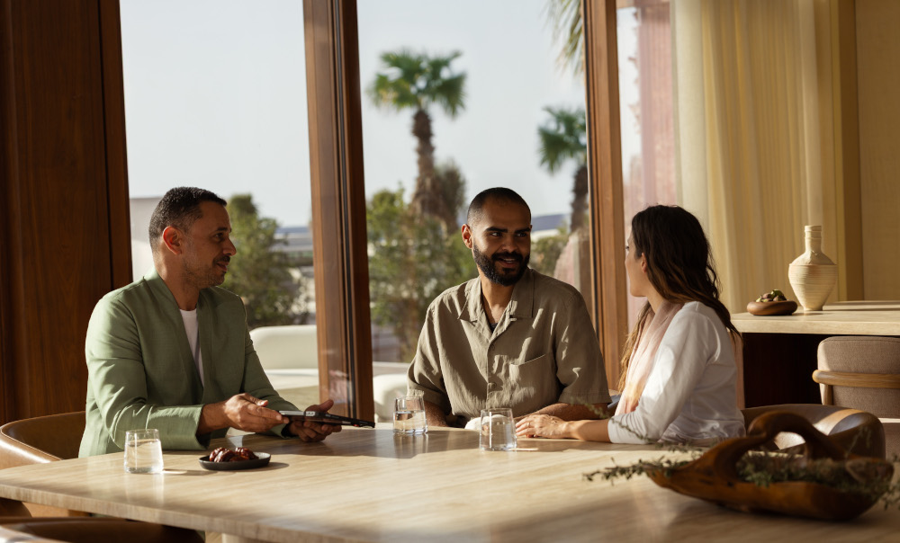 Three people talking round a table