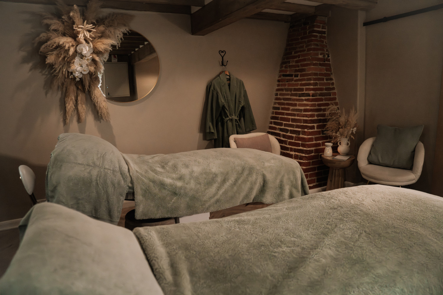 Two spa beds with sage green blankets