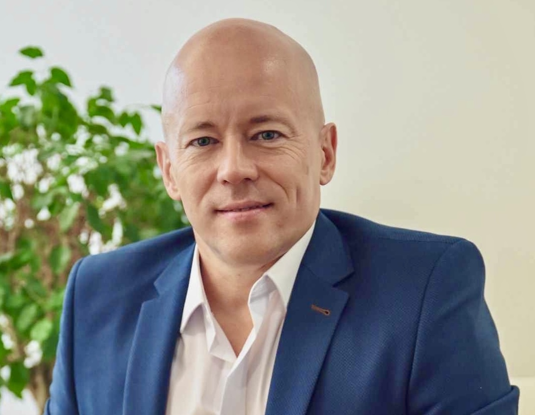 Bald man in blue suit and white shirt