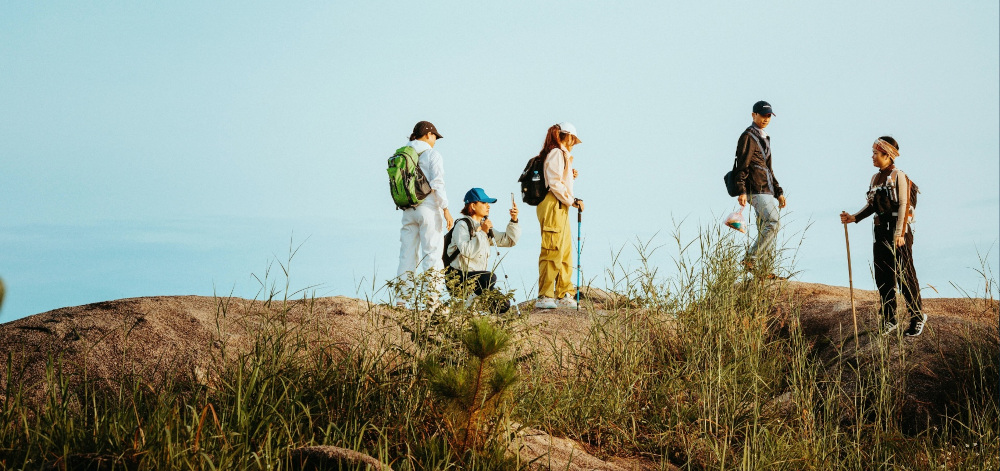People atop a hill on a hike